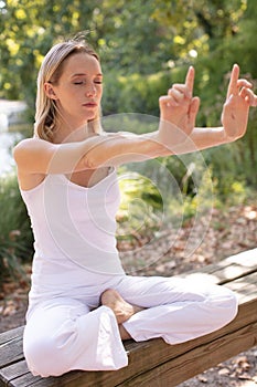 young woman doing yoga outside in natural environment