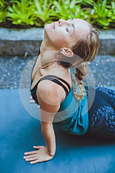 Young woman doing yoga outside in natural environment