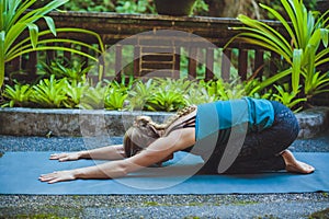 Young woman doing yoga outside in natural environment photo