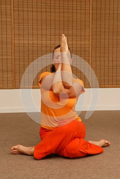 Young woman doing yoga in the sunny room