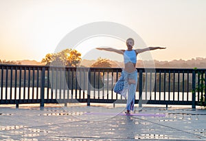 Young woman is doing yoga on the sunrise