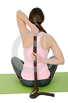 Young woman doing yoga using belt like props