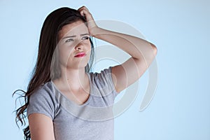 Young woman with doubt expression. Woman scratching her head