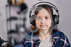 Young woman with down syndrome musician listening to music at music studio