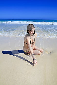 Young woman drawing in the beach sand
