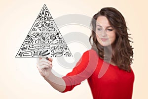 Young woman drawing a food pyramid on whiteboard