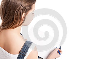 Young woman drawing in her note pad. Back view