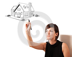 Young woman drawing a house on whiteboard