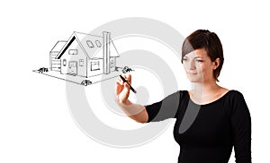 Young woman drawing a house on whiteboard