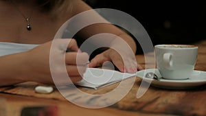 Young woman drawing sitting at table in coffee house.