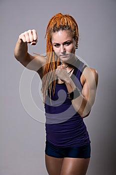 Young woman with dreadlocks in fighting stance