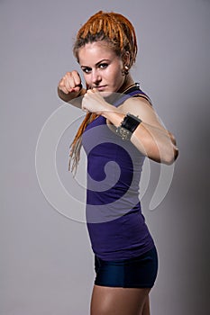 Young woman with dreadlocks in fighting stance