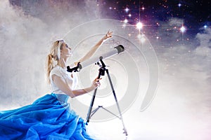 Young woman dreams of the future, concept. Girl looks up and uses a telescope. Starry sky behind the clouds