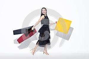 Young woman in dress shopping on white background