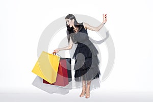 Young woman in dress shopping on white background