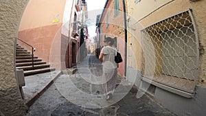 Young woman in a dress walking on the streets of the city of Collioure in the eastern Pyrenees, France