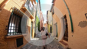 Young woman in a dress walking on the streets of the city of Collioure in the eastern Pyrenees, France