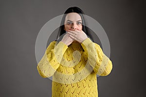 Young woman dressed casually showing symbols of tree wise monkeys