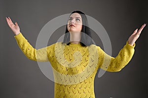Young woman dressed casually thanks with open arms