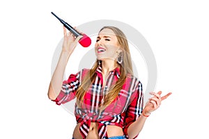 Young woman dressed in jeans and checkered shirt singing