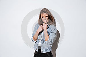 Young woman dressed in jeans jacket standing over white background