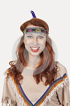 Young woman dressed in old-fashioned costume day dreaming against gray background