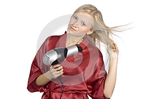 Young woman dressed red bathrobe using hair drier