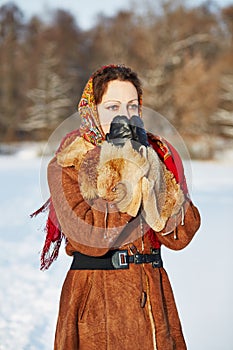 Young woman dressed in sheepskin fur coat and photo