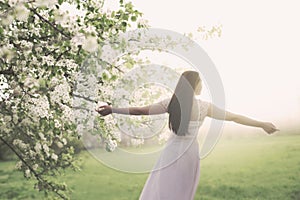 young woman dressed in white taking a breath in the middle of spring nature