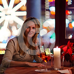 Young woman drining cocktail in restaurant