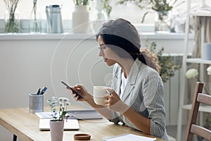 Young woman drink coffee using cellphone gadget