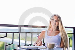 Young woman drink coffee and writing in note book journal in cafe