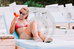 Young woman drinking cocktail in a beach bar