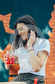 Young woman drinking cocktail in outdoor cafe