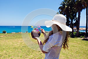 Young Woman drinking Coconut Cocktail at the beach