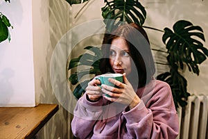 Young woman is drinking coffee in coffee shop. Time for yourself.