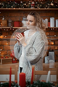 Young woman drinking coffee in kitchen on christmas morning