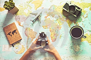 Young woman drinking coffee and planning world tour with vintage travel map - Backpacker girl looking for a new countries to