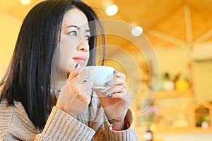 young woman drinking coffee or tea relaxed woman smelling coffee at home in winter with cup coffee, woman coffee with hand holding