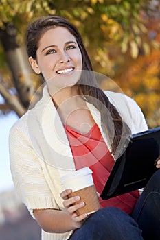 Young Woman Drinking Coffee Using Tablet Computer