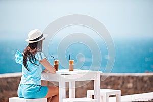 Young woman drinking cold coffee enjoying sea view