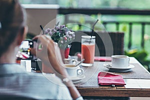 Young woman drinking a cup of coffee in the morning with the jungle view during luxury vacation in Bali island.