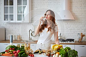 Young woman drinking fresh water from glass in the kitchen. Healthy Lifestyle and Eating. Health, Beauty, Diet Concept