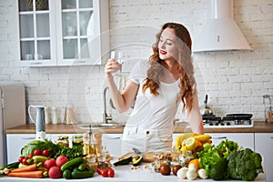 Young woman drinking fresh water from glass in the kitchen. Healthy Lifestyle and Eating. Health, Beauty, Diet Concept