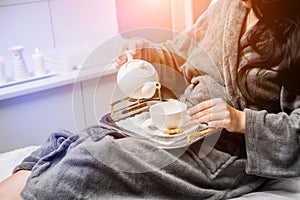 Young woman drinking herbal tea after spa procedures.