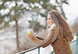 Young woman drinking hot beverage in winter park