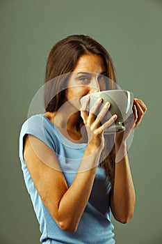 Young woman drinking from large cup