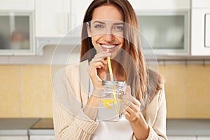 Young woman drinking lemon water