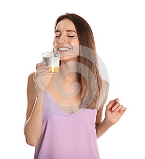 Young woman drinking lemon water on background