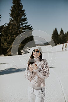Young woman drinking lemonade  on the mountain ski track